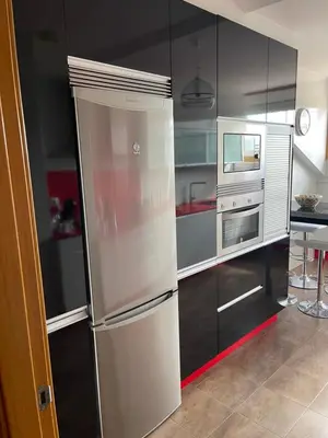 a stainless steel refrigerator in a kitchen with black cabinets at Suite Azucarera in Iria