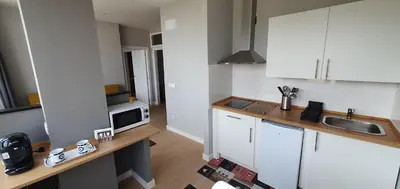 a kitchen with white cabinets and a sink and a microwave at Pisos uso turistico Torno-Cubelas-Caosa Buenavista in San Ciprián