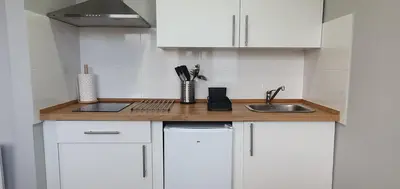 a kitchen with white cabinets and a sink at Pisos uso turistico Torno-Cubelas-Caosa Buenavista in San Ciprián