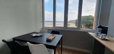 a dining room with a table and a view of the beach at Pisos uso turistico Torno-Cubelas-Caosa Buenavista in San Ciprián
