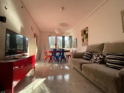 a living room with a couch and a table with chairs at Piso BOLBORETEIRO in Allariz