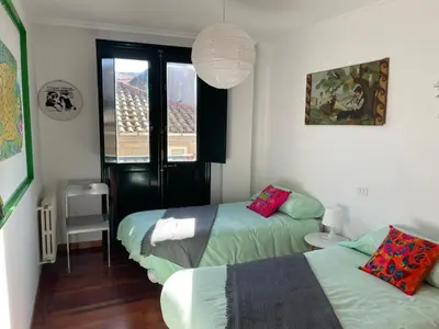 a bedroom with two beds and a window at Piso BOLBORETEIRO in Allariz
