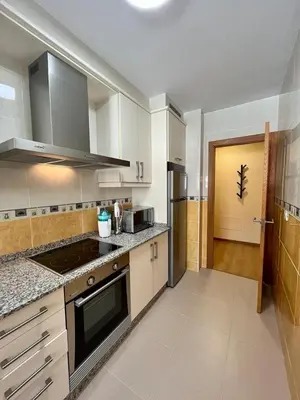 a kitchen with white cabinets and a stove top oven at Centro de Miño - Pumariega in Miño