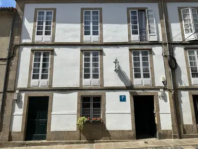 a building with a statue on the side of it at Casa Anglicana del Peregrino/ Pensión Santa Cristina in Santiago de Compostela