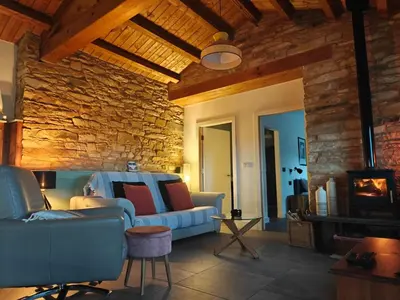 a living room with a couch and a stone wall at La Casita in Lugo
