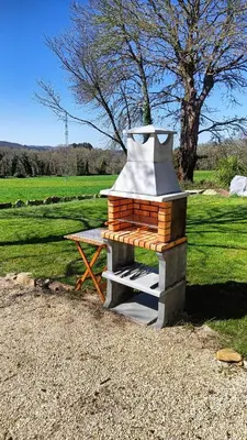 a woodburning stove with a picnic table in a field at La Casita in Lugo