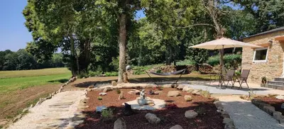 a garden with a hammock and an umbrella at La Casita in Lugo