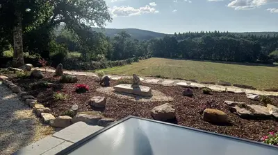 a backyard garden with rocks and a pond at La Casita in Lugo