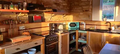 a kitchen with a stove and a microwave in it at La Casita in Lugo