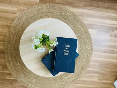 a table with a plate with a book and flowers at Bodega Sibeiro in Chantada