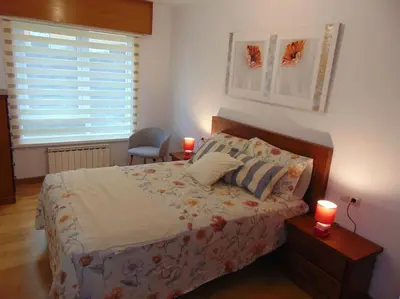 a bedroom with a bed with two candles on it at apartamento con jardin in Santiago de Compostela