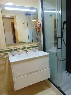 a bathroom with a sink and a glass shower at apartamento con jardin in Santiago de Compostela