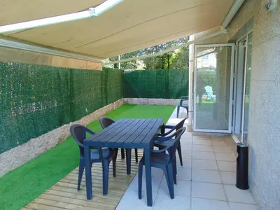 a blue table and chairs on a patio with grass at apartamento con jardin in Santiago de Compostela