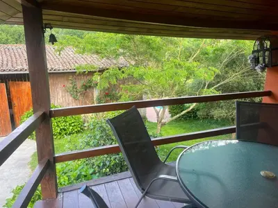 a table and chairs on a porch with a view at Casa CACHAMARIA próxima a la ribeira sacra in Ourense