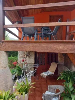 a screened in porch with chairs and a swing at Casa CACHAMARIA próxima a la ribeira sacra in Ourense