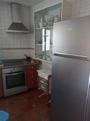 a kitchen with a stainless steel refrigerator and a stove at Casa CACHAMARIA próxima a la ribeira sacra in Ourense
