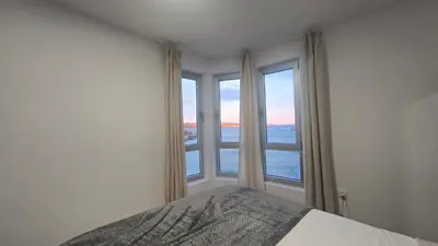 a bedroom with a bed and a large window at C&C Suite in San Ciprián