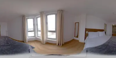 a bedroom with two beds and two large windows at C&C Suite in San Ciprián