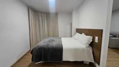 a bedroom with a bed with white sheets and pillows at C&C Suite in San Ciprián
