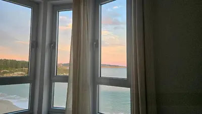 a room with three windows looking out at the ocean at C&C Suite in San Ciprián