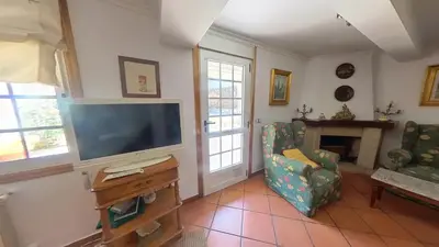 a living room with a flat screen tv and a chair at Mirador del castillo in Monforte de Lemos