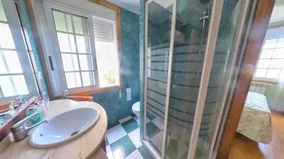 a bathroom with a sink and a glass shower at Mirador del castillo in Monforte de Lemos