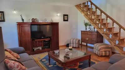 a living room with a staircase and a television at Mirador del castillo in Monforte de Lemos