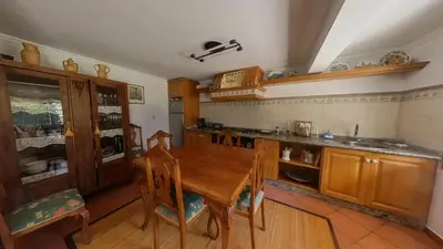 a kitchen with a wooden table and wooden chairs at Mirador del castillo in Monforte de Lemos