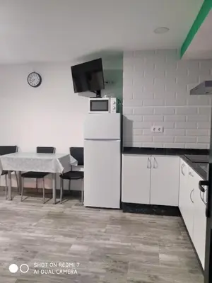 a kitchen with a refrigerator and a table with chairs at O RECUNCHO DE BERE in Ribadeo