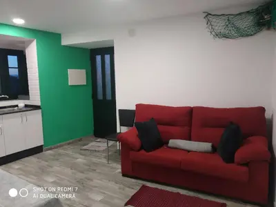 a red couch in a living room with green walls at O RECUNCHO DE BERE in Ribadeo