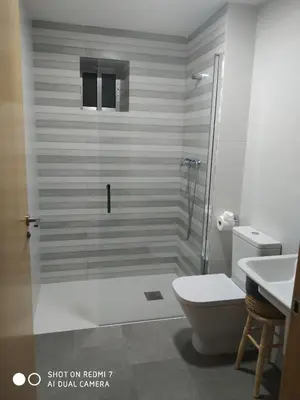 a bathroom with a shower with a toilet and a sink at O RECUNCHO DE BERE in Ribadeo