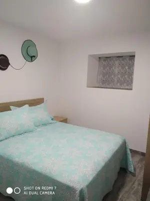 a bedroom with a bed with a blue comforter at O RECUNCHO DE BERE in Ribadeo
