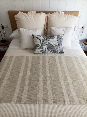 a bed with white pillows and a blanket on it at O balcón do Río in Caldas de Reis