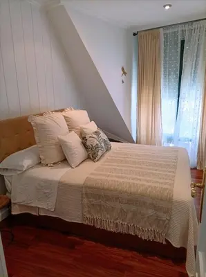 a bedroom with a bed with pillows and a window at O balcón do Río in Caldas de Reis