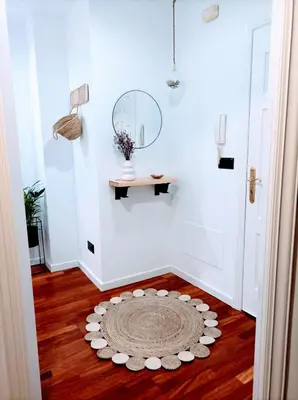 a hallway with a rug on the floor and a mirror at O balcón do Río in Caldas de Reis