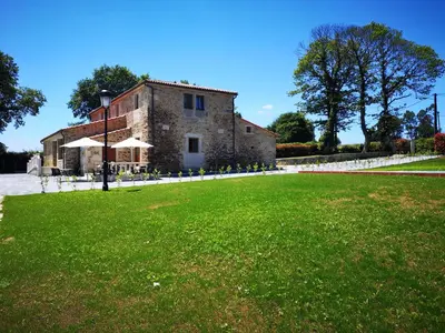 an old stone building with a grass field in front of it at Casa Rural Camino Real Completa in Melide