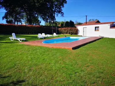 a swimming pool in a yard with two lawn chairs at Casa Rural Camino Real Completa in Melide