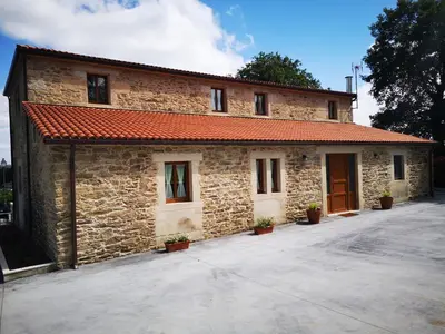 a stone building with a red roof at Casa Rural Camino Real Completa in Melide