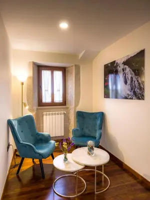 two blue chairs and a table in a room at Casa Rural Camino Real Completa in Melide