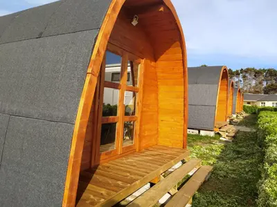 a wooden cabin with a window on a roof at Bungalow 3 personas - Camping Playa de Tapia in Tapia de Casariego