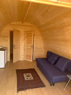 a living room with a blue couch in a wooden room at Bungalow 3 personas - Camping Playa de Tapia in Tapia de Casariego