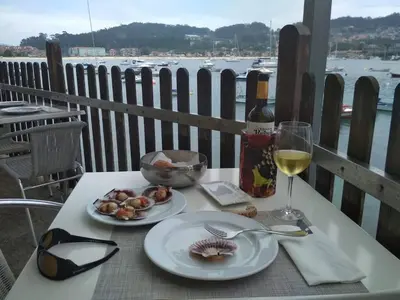 a table with two plates of food and a glass of wine at Casa Rural Turística Casa Nicolau 1 in Barbudo