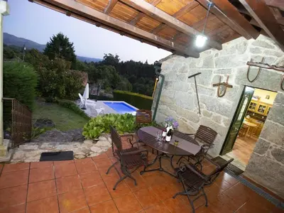 a patio with a table and chairs and a pool at Casa Rural Turística Casa Nicolau 1 in Barbudo