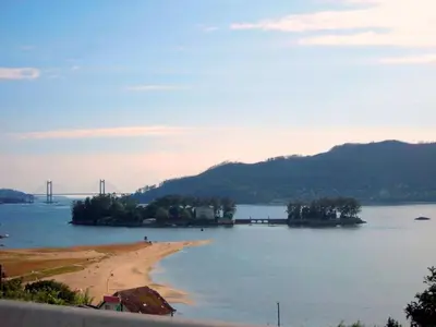 a large body of water with a beach and a bridge at Casa Rural Turística Casa Nicolau 1 in Barbudo
