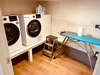 a laundry room with a washing machine and a stool at Villa Clásica en Santiago 