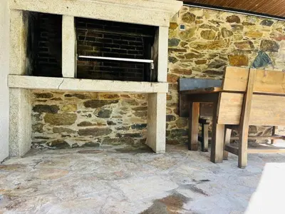 a stone fireplace with a wooden chair in front of it at Villa Clásica en Santiago 