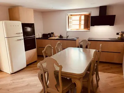 a kitchen with a table and a white refrigerator at Villa Clásica en Santiago 